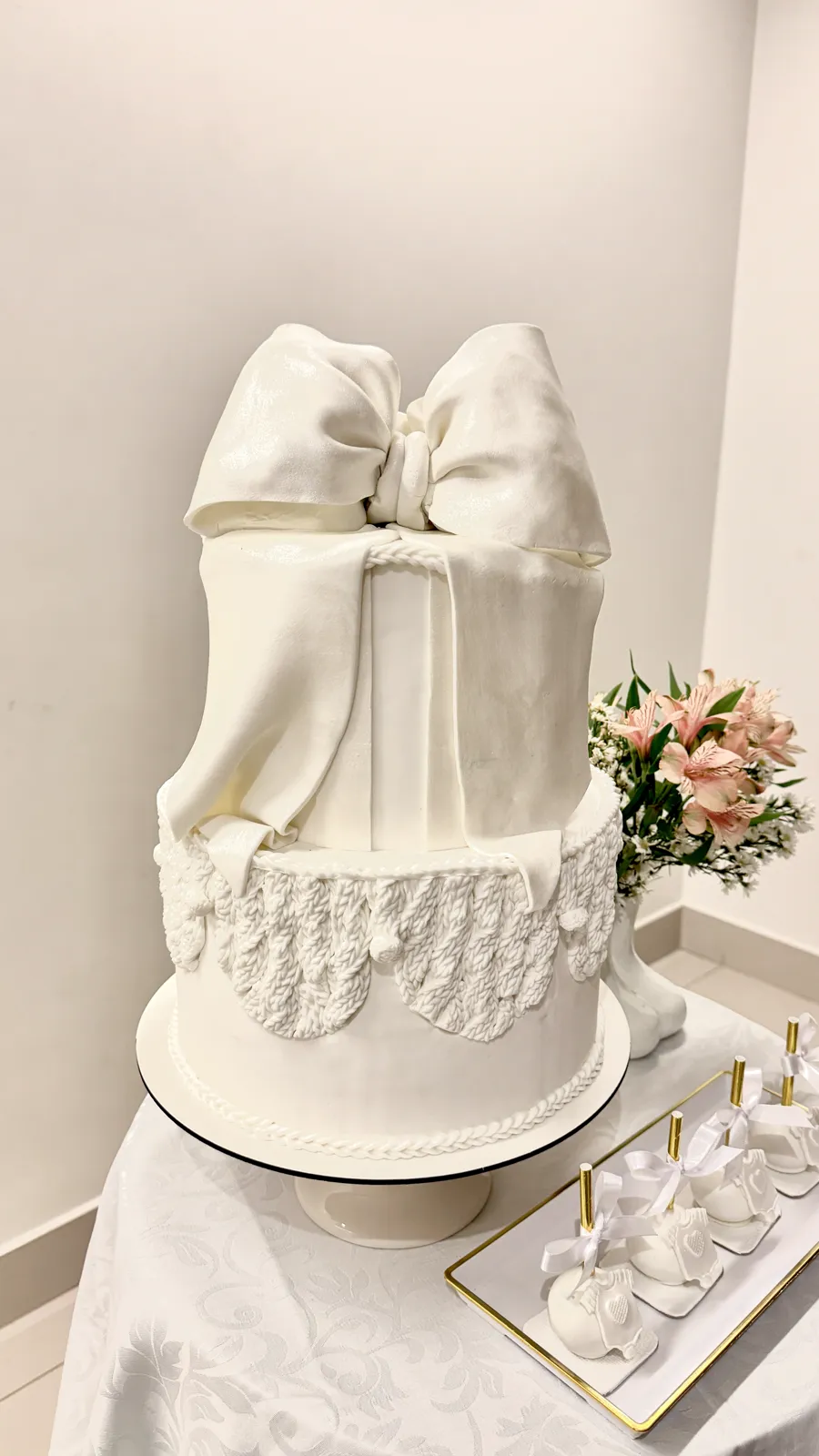Bolo branco com laço de chocolate, detalhe artesanal da Duetto